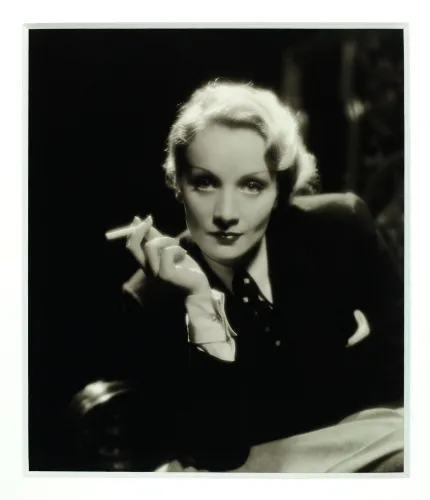 Dietrich looking into the camera and brandishing a cigarette.