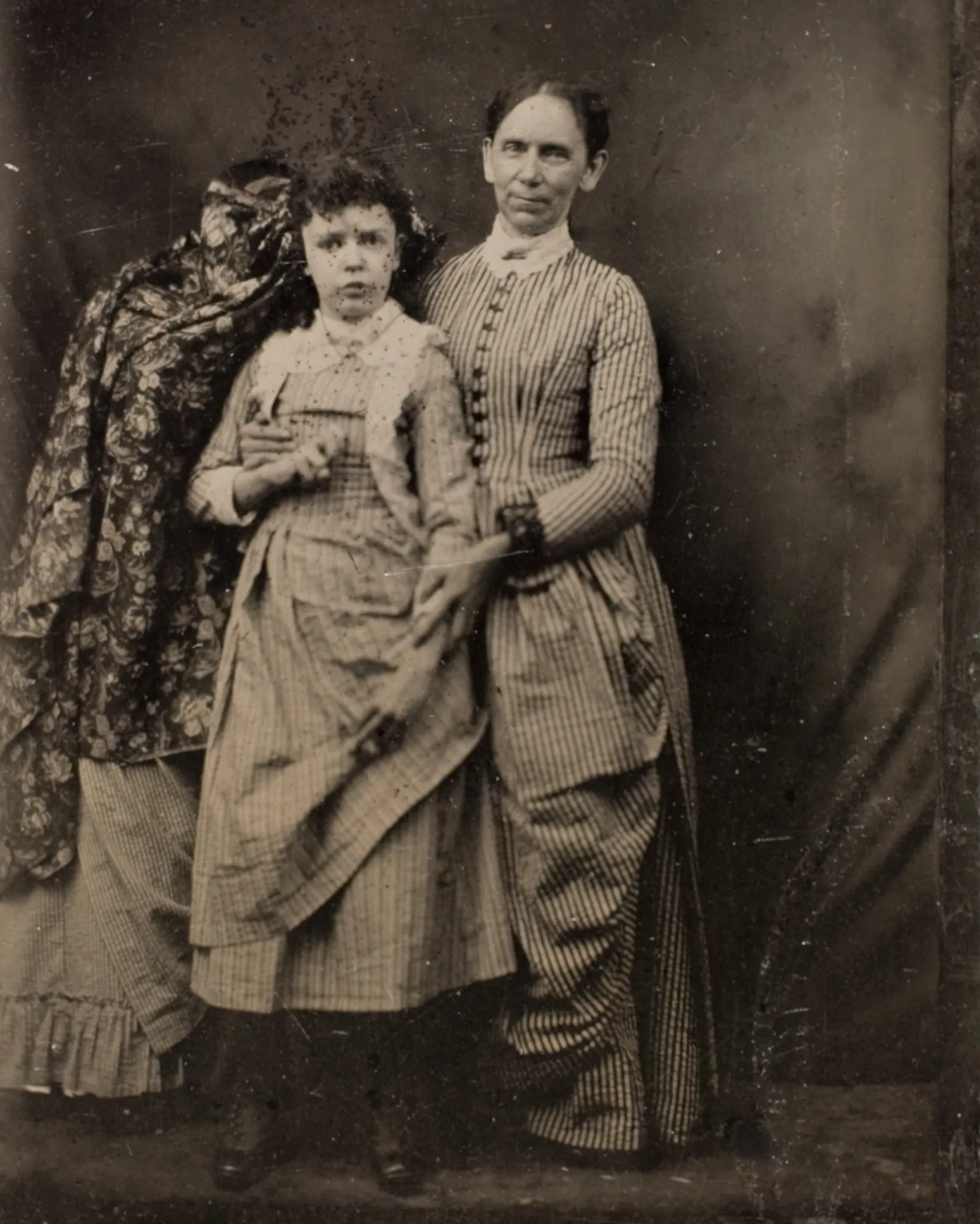 A woman and her daughter posing for the camera. 